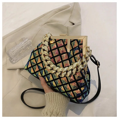 Colorful patterned handbag with a gold chain handle held by a person wearing a beige sweater.