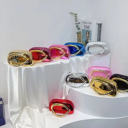 Colorful metallic Carauana Festival Clutch Bag  on a white surface with a magazine in the background.