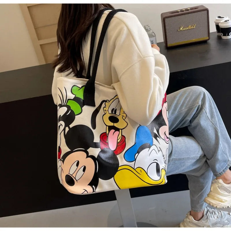 Person wearing a hoodie with cartoon character design, sitting on a chair.