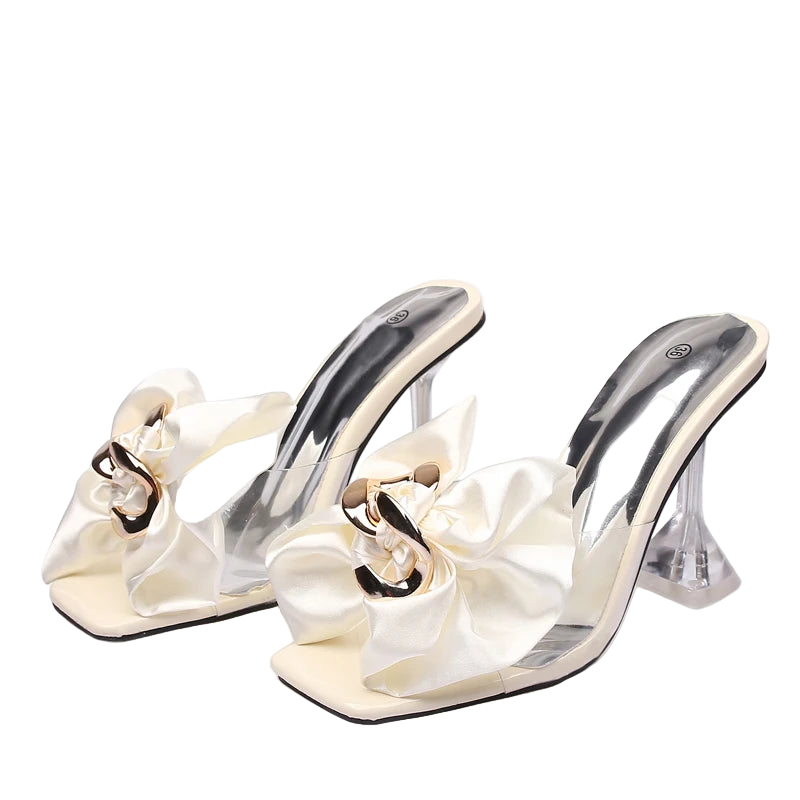 White high-heeled shoes with decorative ribbons
