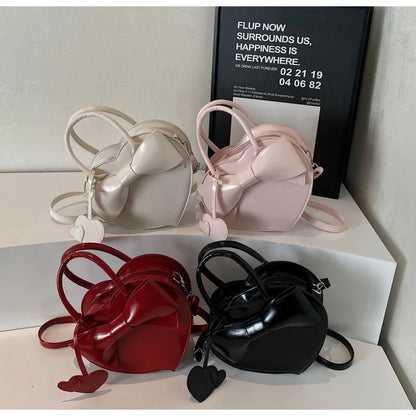 Four small handbags in red, black, pink, and white on a white surface.